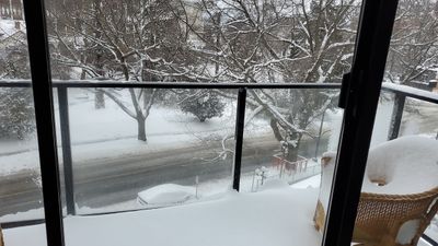A snowy balcony and street below