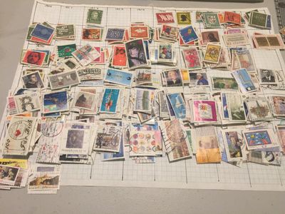 a table full of roughly sorted postage stamps