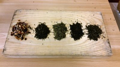 an assortment of loose tea, presented on a wooden board