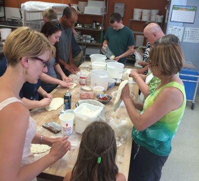 Trying their hands at tossing pizza dough!