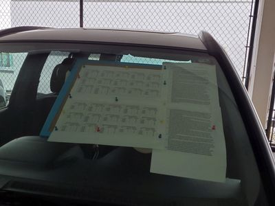 notices taped on a car window